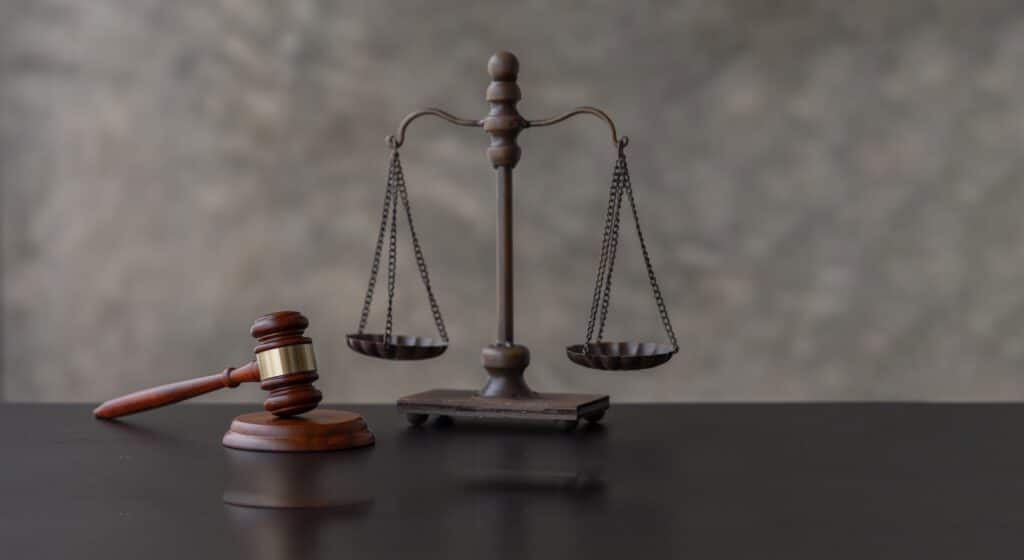 Wide panorama view of wooden gavel with golden scale on table Law and justice concept.