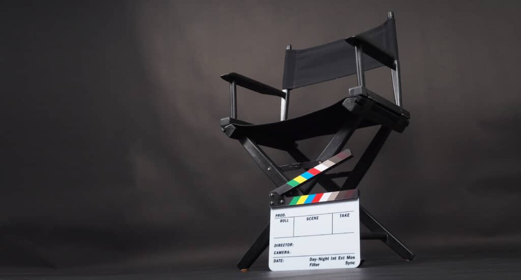 Black director chair and Clapper board on black background.