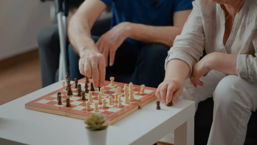 Intellectual people playing chess game with pieces and board