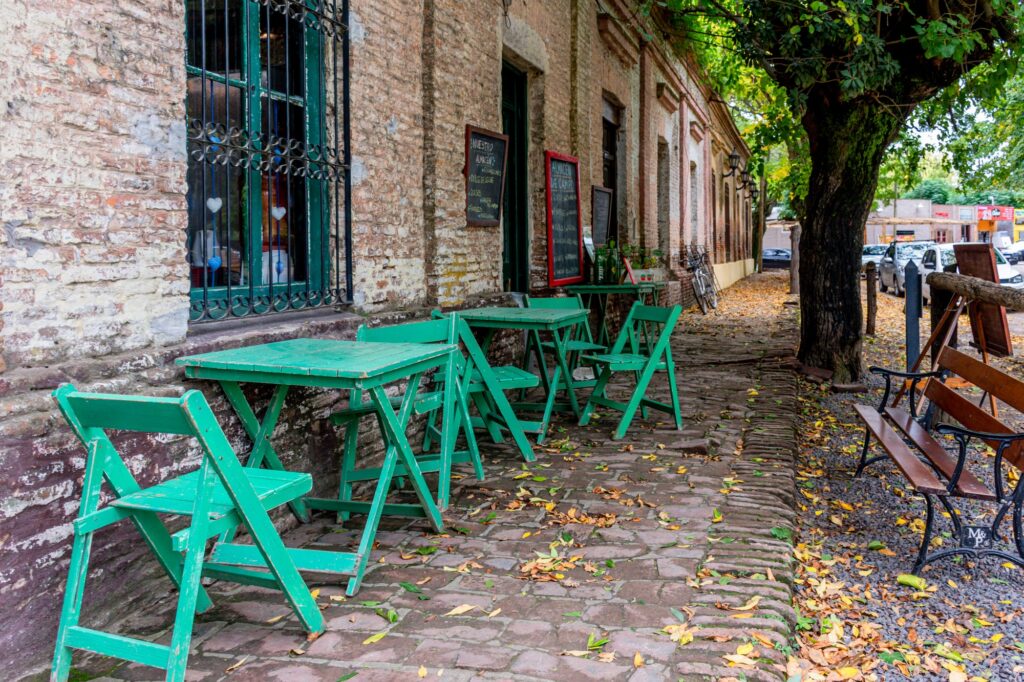 Bright green chairs and tables outside an old restaurant