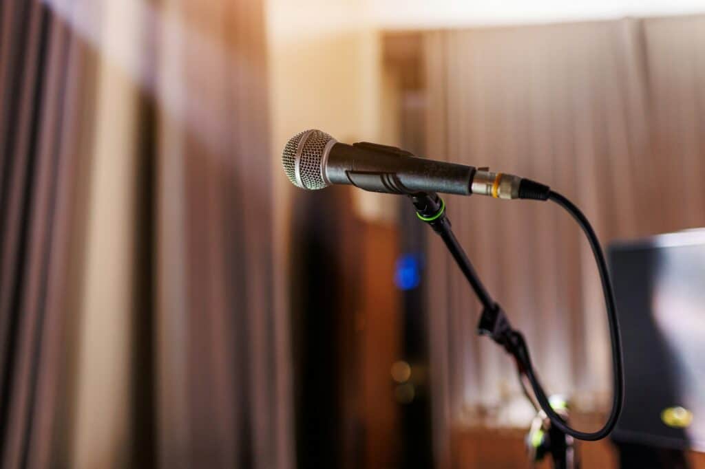Microphone on stand on stage close up with searchlight light. Professional mic at concert hall or