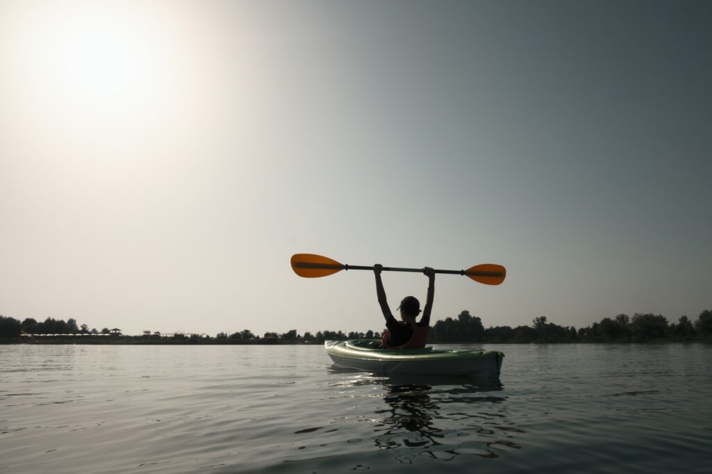 Boy in life jacket on green kayak